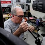 Apprentice working at a manufacturing facility with goggles on