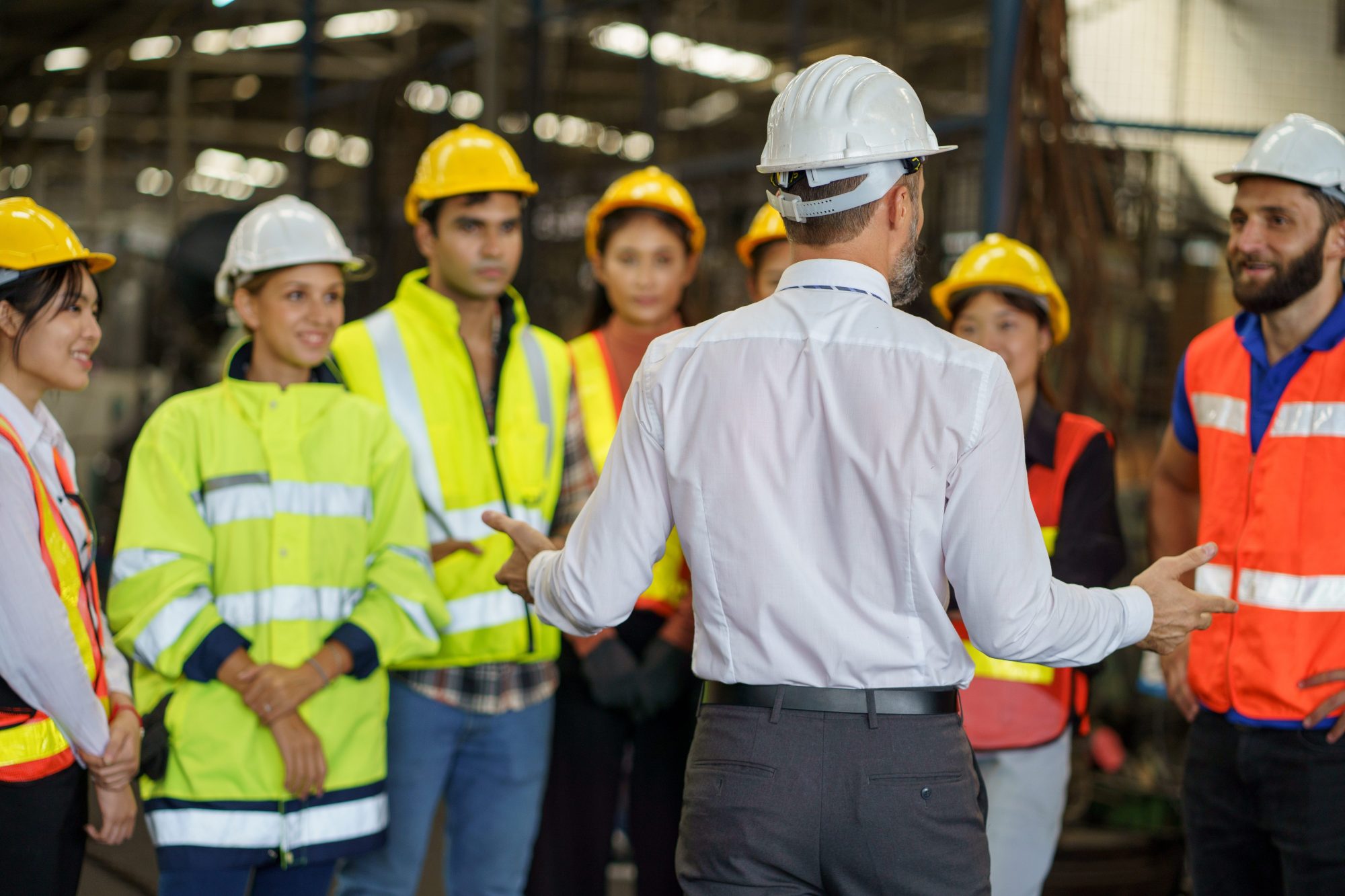 Man explaining to young adults how the factory works and how their skills will be used