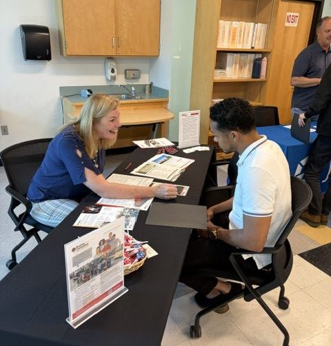 Employer enthusiastically speaking with student at job fair